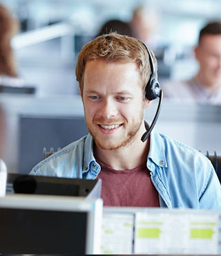 Happy smiling customer service operator works at the computer in the office