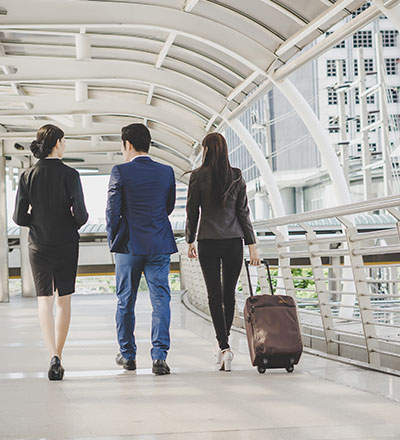 Business people walking through a building with luggage